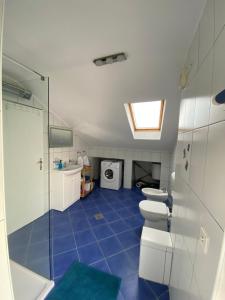 uma casa de banho com um WC, um lavatório e uma máquina de lavar roupa em Apartman S&D Rogoznica em Rogoznica