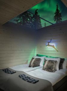 Una cama en una habitación con una pared con un cartel. en Skyfire Village Igloos, en Rovaniemi