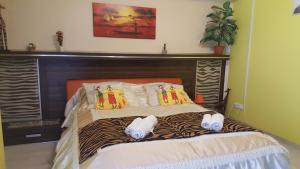 ハイドゥソボスローにあるSafari Apartmanのベッド(シマウマの枕、靴付)