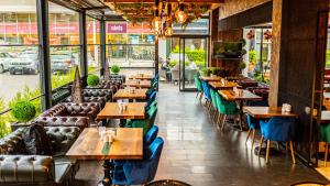 a restaurant with wooden tables and blue chairs at Aselia Hotel Trabzon in Trabzon