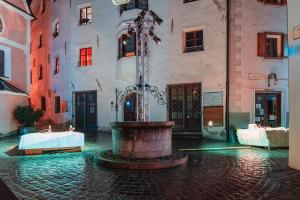a building with a fountain in the middle of a street at Villa Kranebitt in Bressanone
