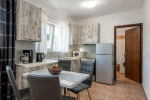 una cucina con tavolo e frigorifero di Elenas Village house - Dream apt w Pool & Terrace a Alikianós