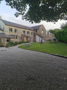 une grande maison en briques avec une allée en gravier dans l'établissement THE OLD RECTORY SOUTHCOTT APARTMENT in Jacobstow 10 mins to Widemouth bay and Crackington Haven,15 mins Bude,20 mins tintagel, 27 mins Port Issac, à Jacobstow