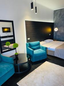 Odessa的住宿－Club House Arkadia Beach，一间卧室配有一张床、一张沙发和一把椅子