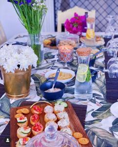 a table with a table cloth with food on it at WHITE Nyumba Malindi - Boutique Villa in Malindi