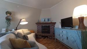 sala de estar con sofá, TV y chimenea en Casa Dolfín - "Tu hogar en la costa del paraíso" en Naves