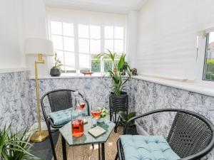 a room with two chairs and a table with drinks on it at 18 Tyn Celyn in Llandudno