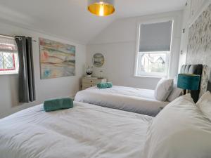 a bedroom with two beds and two windows at 18 Tyn Celyn in Llandudno