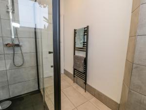 a bathroom with a shower with a glass door at 18 Tyn Celyn in Llandudno +27 photos