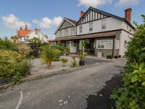 a large white house with a driveway at 18 Tyn Celyn in Llandudno
