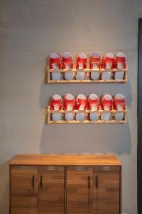 a row of red and white bowls on a shelf at Corner Hostel & Cafe in Taipei