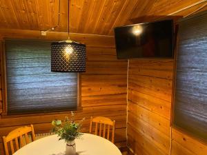 a dining room with a table and a television at Camping Fredrika-Braber in Fredrika