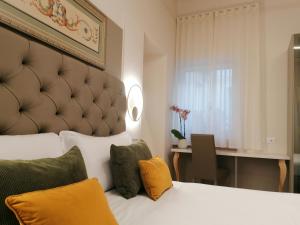 a bedroom with a large white bed with yellow pillows at Palazzo Cortesi Boutique Hotel in Macerata
