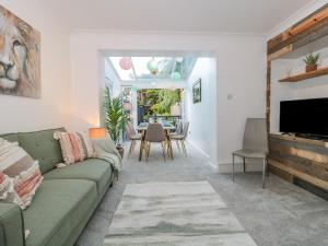 a living room with a green couch and a table at Forever Summer in Lymington