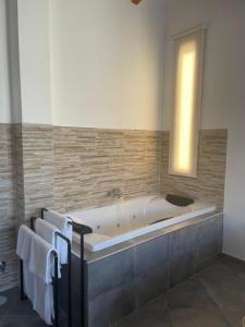 La salle de bains est pourvue d'une baignoire, de serviettes et d'une fenêtre. dans l'établissement El Cobijo de Gredos, à Navaluenga
