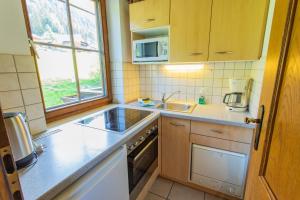 a small kitchen with a sink and a stove at Huberhof 7 by Alpenidyll Apartments in Schladming