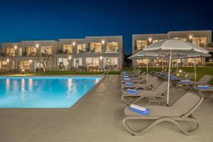 a pool with chairs and umbrellas in front of a hotel at Maj Luxury Residence in Poreč