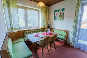 a dining room with a table and green chairs at Huberhof 6 by Alpenidyll Apartments in Schladming