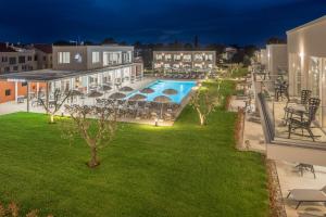 an apartment patio with a swimming pool at night at Maj Luxury Residence in Poreč