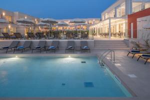 a large swimming pool with chairs and a building at Maj Luxury Residence in Poreč