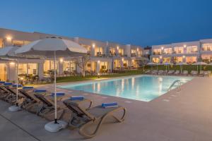 a swimming pool with lounge chairs and umbrellas at Maj Luxury Residence in Poreč