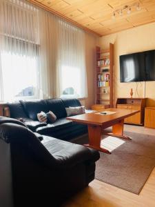 ein Wohnzimmer mit einem Sofa und einem Holztisch in der Unterkunft City Müllers Apartment in Bremerhaven