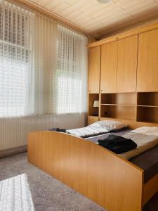 1 Schlafzimmer mit 2 Betten und einem großen Kopfteil aus Holz in der Unterkunft City Müllers Apartment in Bremerhaven