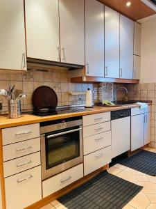 eine Küche mit weißen Schränken und einem Backofen in der Unterkunft City Müllers Apartment in Bremerhaven