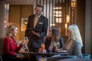 a group of people sitting around a table in a restaurant at Maldron Hotel Manchester City Centre in Manchester