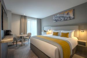 a hotel room with a large bed and a table at Maldron Hotel Manchester City Centre in Manchester