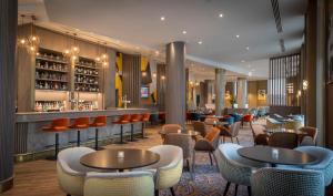 a restaurant with tables and chairs and a bar at Maldron Hotel Manchester City Centre in Manchester