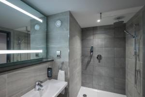 a bathroom with a sink and a shower at Maldron Hotel Manchester City Centre in Manchester