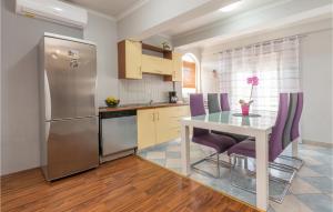 eine Küche mit einem Tisch und einem Kühlschrank aus Edelstahl in der Unterkunft Lovely Home In Biograd Na Moru With Kitchen in Biograd na Moru