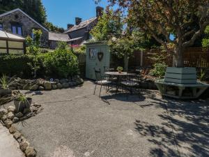 a patio with a table and chairs in a yard at Crabapple Cottage in Llanfairfechan