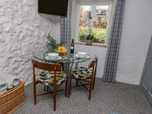 a dining room table with two chairs and a window at Crabapple Cottage in Llanfairfechan