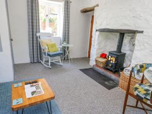 a living room with a fireplace and a table at Crabapple Cottage in Llanfairfechan