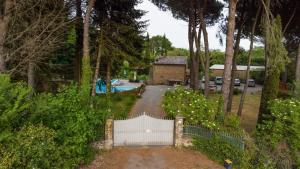 a driveway with a white fence and a house at Dependance Villa Settecamini in Porano