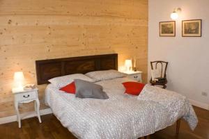 My Heart in Argegno - by My Home In Como في آرجينيو: غرفة نوم عليها سرير ومخدات حمراء
