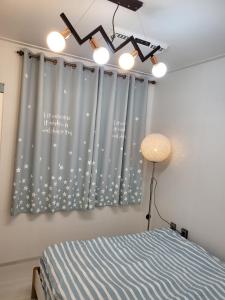 a bedroom with a bed and a window with stars at Petit House in Sokcho