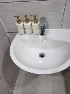 a white sink with four bottles on top of it at Petit House in Sokcho