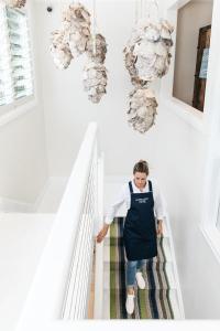 Eine Frau in einer Schürze, die eine Treppe hinuntergeht. in der Unterkunft Barrenjoey House in Palm Beach