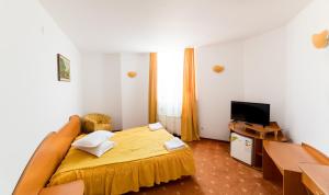 a bedroom with a bed and a flat screen tv at Hotel Atlantis in Tulcea