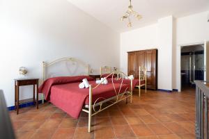 a bedroom with a bed with a red comforter at Al Palmento Cruillas in Siracusa