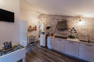 a kitchen with wooden floors and a brick wall at Dependance Villa Settecamini in Porano +38 photos