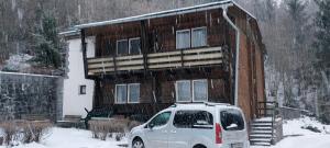 a van parked in front of a house in the snow at Penzion Svojanov in Svojanov