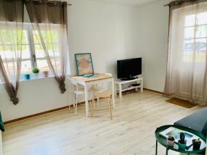 a living room with a table and a television at APPARTEMENT T2 GUETHARY CENITZ in Guéthary