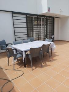 una sala conferenze con tavolo e sedie bianchi di La Palmera a Estepona