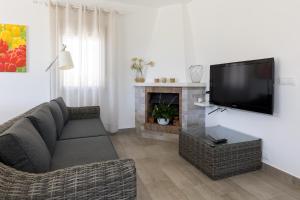 een woonkamer met een bank en een flatscreen-tv bij Villa Vistamar in Punta Grossa
