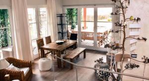 a living room with a wooden table and a dining room at LOVELY IN Boutique-Hotel VELDEN in Velden am Wörthersee