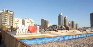 a beach with a fountain with a heart sculpture at beach front tel aviv bat yam apartment -hotel 39 in Bat Yam
